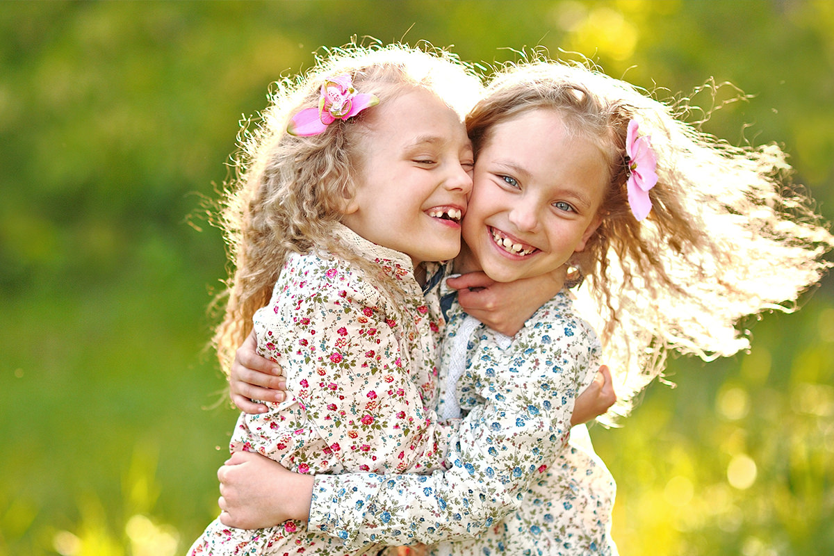 Twin Girls Smiling and Hugging Each Other