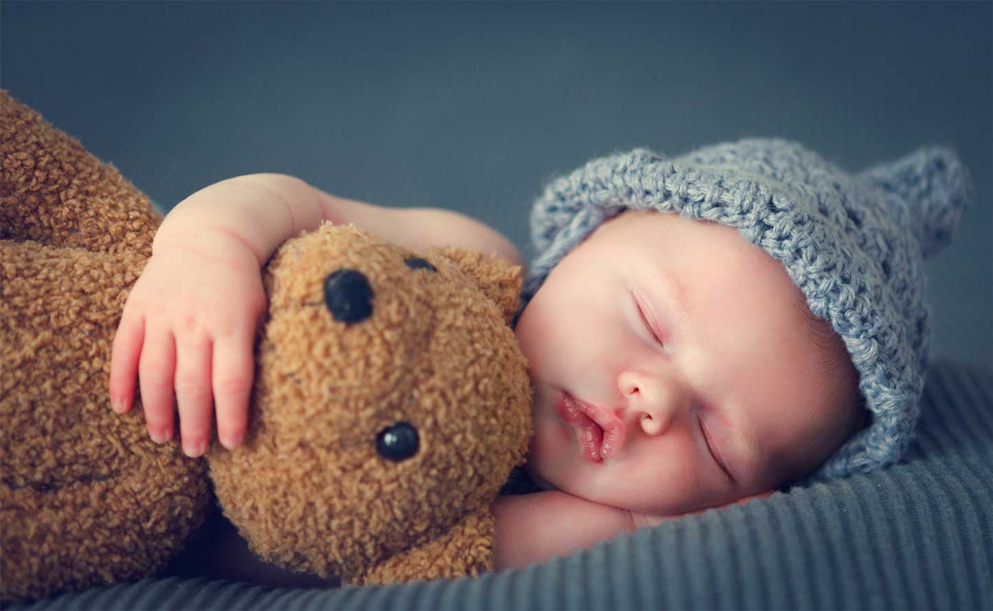 Baby Holding Teddy while Sleeping